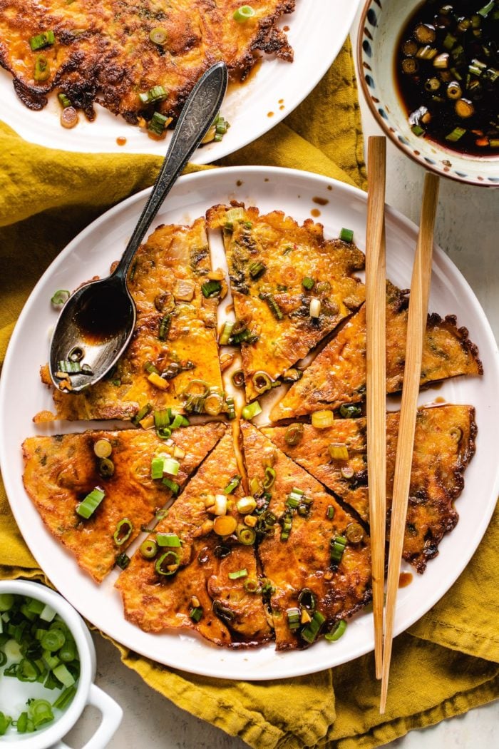 Photo shows serving the sliced kimchi pancakes with dipping sauce on the side