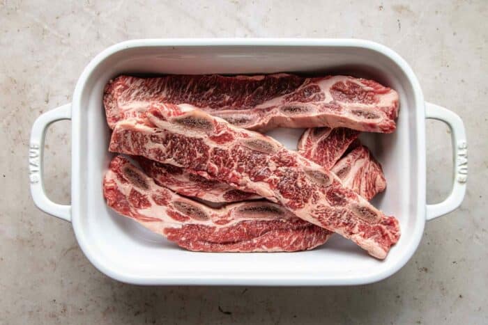 LA galbi with flanken cut beef short ribs in a white ceramic container