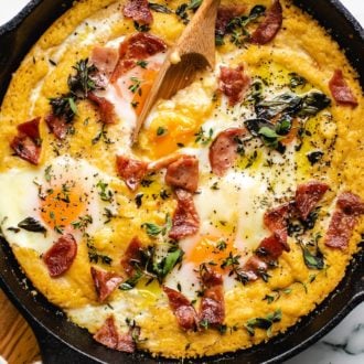 grits with creamy egg yolks served in a cast iron skillet