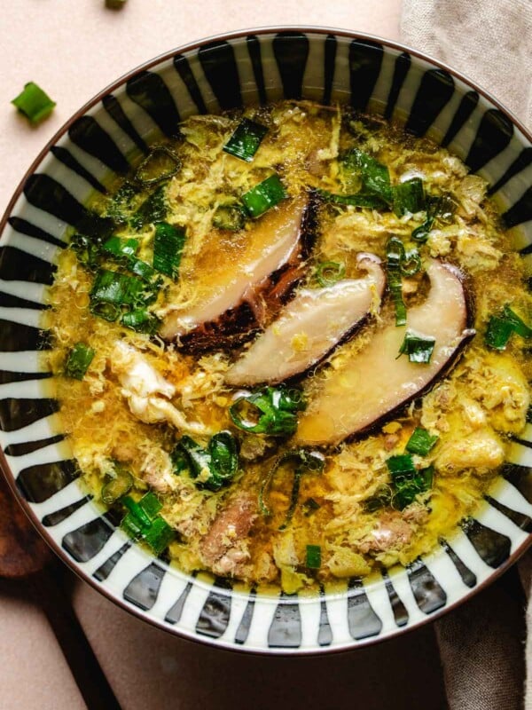 Image shows a bowl of healthy nutritious paleo egg drop soup with shiitake, ground meat in a savory soup broth.