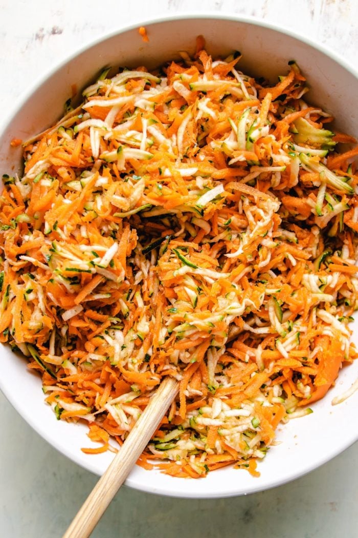 Photo shows a big white bowl with shredded zucchini and carrots