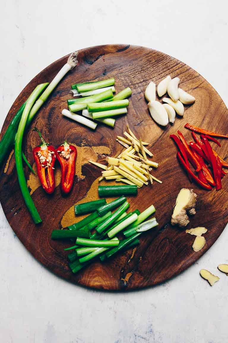 Photo shows aromatic ingredients sliced and diced ready to use on a chopping board