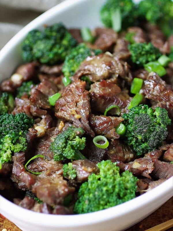 Image shows velveted beef stir fried with crisp broccoli and served in a white color plate.