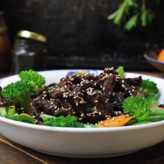 Paleo crispy sesame beef ! Thin sliced sirloin steak pan fried to golden crispy paired with light refreshing veggies. Healthy and super-delicious sesame beef that won't weigh you down. Paleo Chinese takeout. IHeartUmami.com