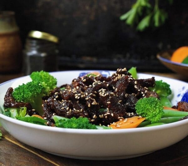 Paleo crispy sesame beef ! Thin sliced sirloin steak pan fried to golden crispy paired with light refreshing veggies. Healthy and super-delicious sesame beef that won't weigh you down. Paleo Chinese takeout. IHeartUmami.com