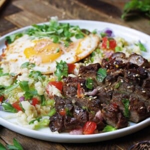 Paleo Filipino Skirt Steak Cauliflower Fried Rice ! Low carb cauliflower fried rice with gluten-free steak marinade pan seared in cast iron skillet. Add this easy healthy recipe to your Paleo, Keto, and Whole30 meal plan. Follow the link for quick video tutorial + print the recipe !