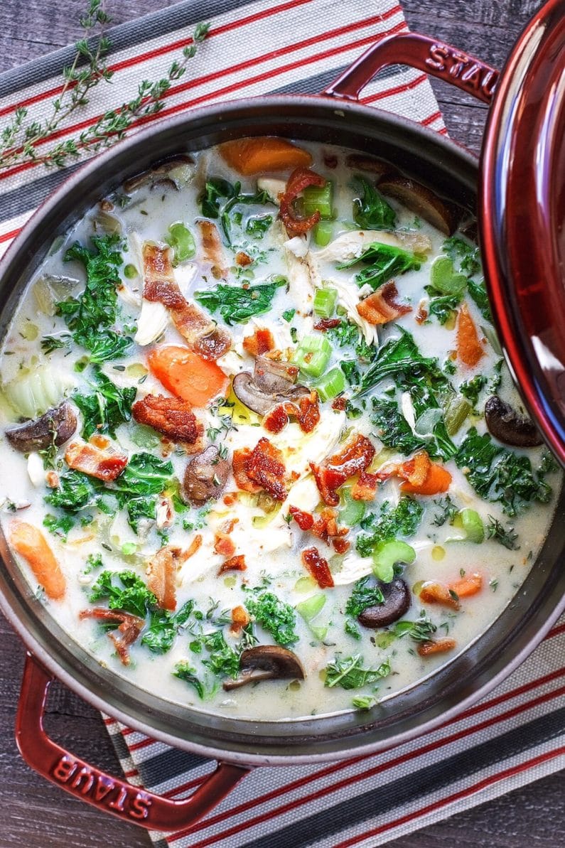 Feature image shows creamy chicken with kale and bacon crumbles in creamy chicken broth in a Dutch oven.