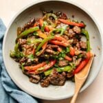A recipe image shows pepper beef stir fry with onions served on a light color plate