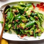 Chinese cucumber smashed and served on a white plate with dressing