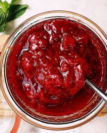 Feature image shows delicious strawberry compote served chilled in a glass jar that's spoonable.