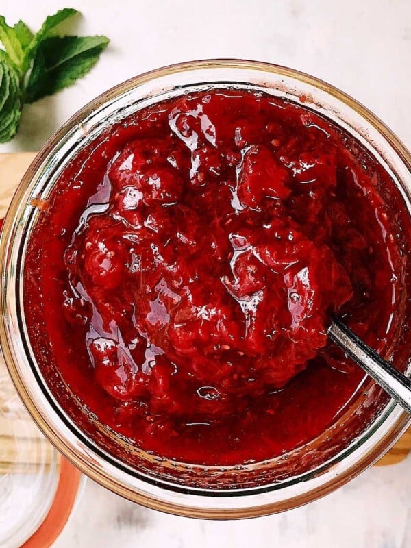 Feature image shows delicious strawberry compote served chilled in a glass jar that's spoonable.