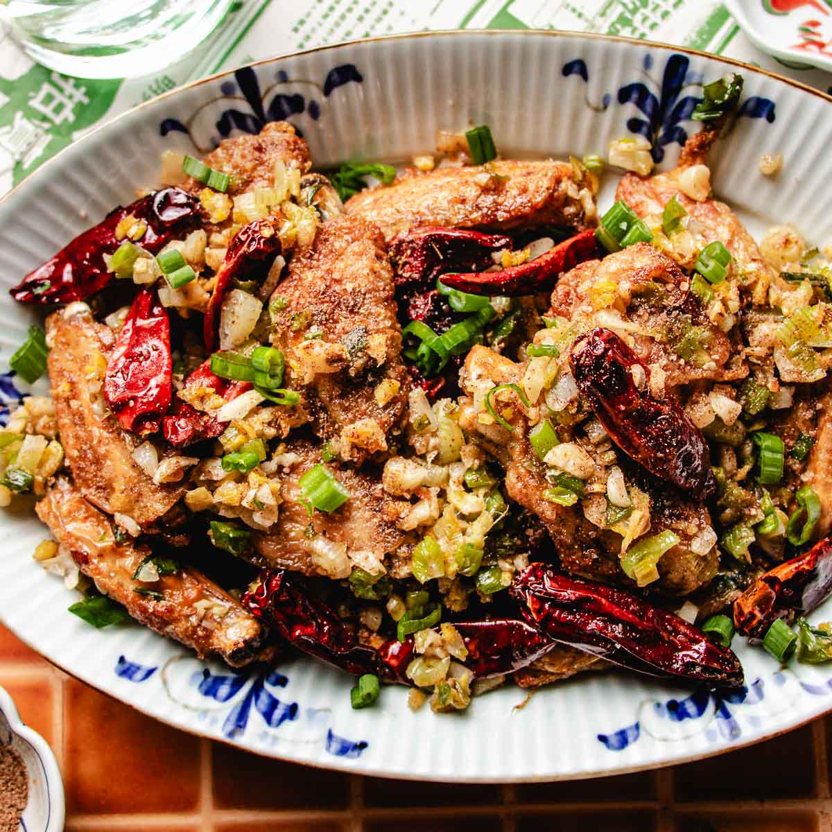 Recipe image shows crispy oven fried Chinese chicken wings served in a blue white color plate.