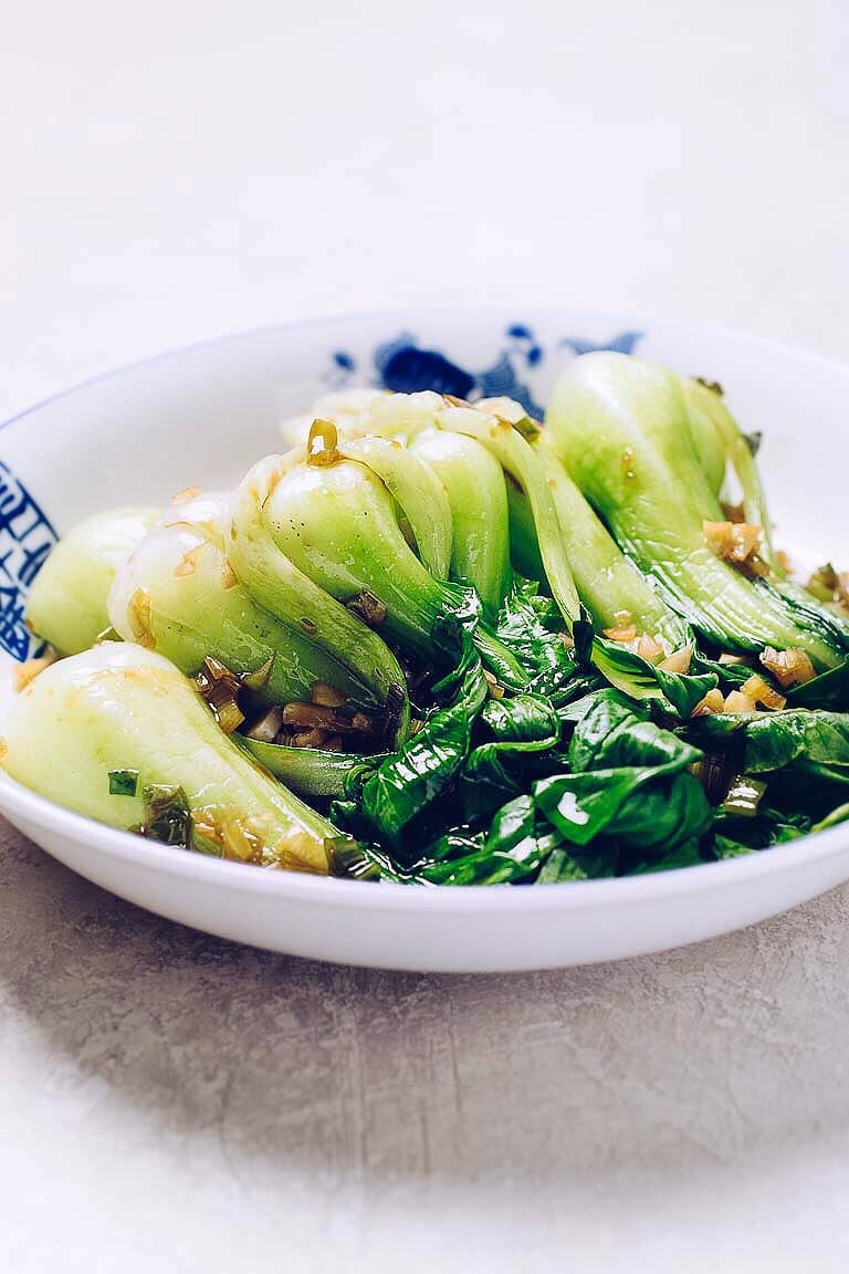 A side photo shows bok choy blanched and pile up in a plate with sauce over.
