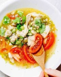 Paleo Chicken Pho Soup recipe with tomatoes, simmered with juicy chicken thighs and lemon and lime zest in a clear chicken broth.