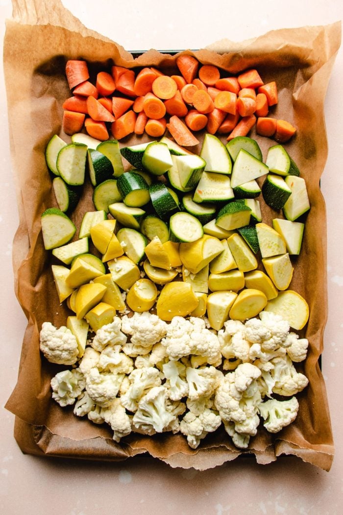 Phot shows vegetables diced up in a sheet pan and ready to be roasted