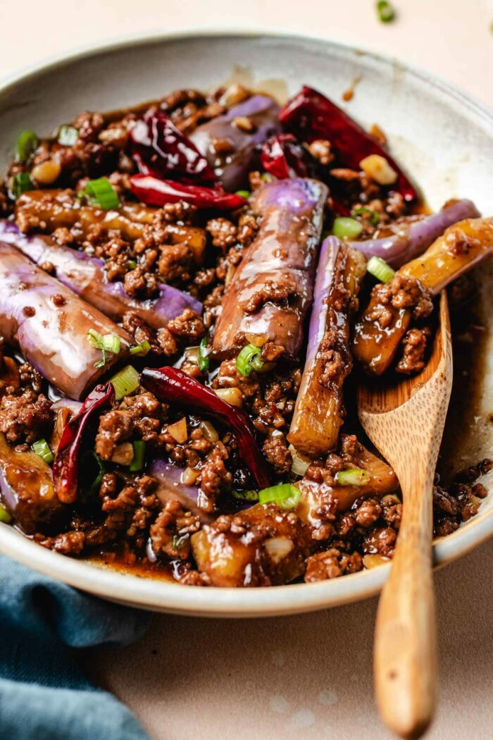 A side close shot shows Chinese eggplants stir fried in garlic sauce and served on a white plate