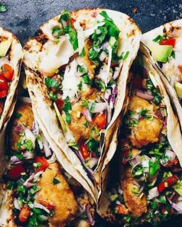 Paleo fish tacos recipe with gluten-free tortillas and tempura fish fillets and salsa sauce.