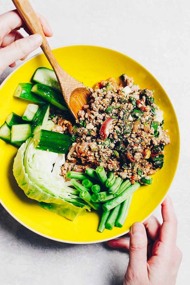 Photo shows Thai Larb Recipe (Larb Moo) dish served with fresh vegetables on the side in a bright yellow bowl.