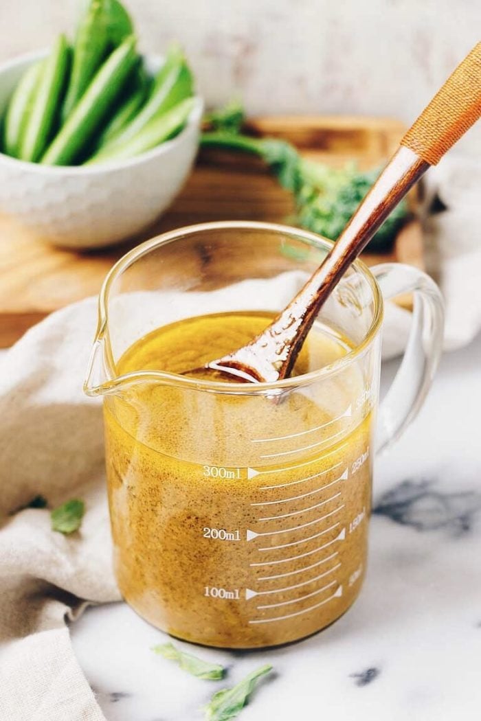 Image shows a glass jar of creamy Asian ginger mustard dressing.