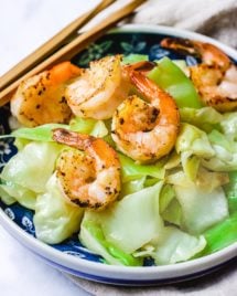 Feature image shows Taiwanese cabbage sauteed and served in a blue white colored plate, served with an optional topping - seared shrimp.