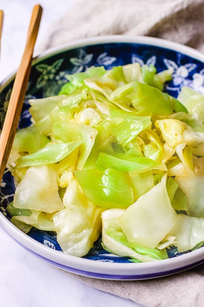 Photo shows simple sauteed Taiwanese cabbage that is juicy, tender, and crisp, served in a blue color plate.