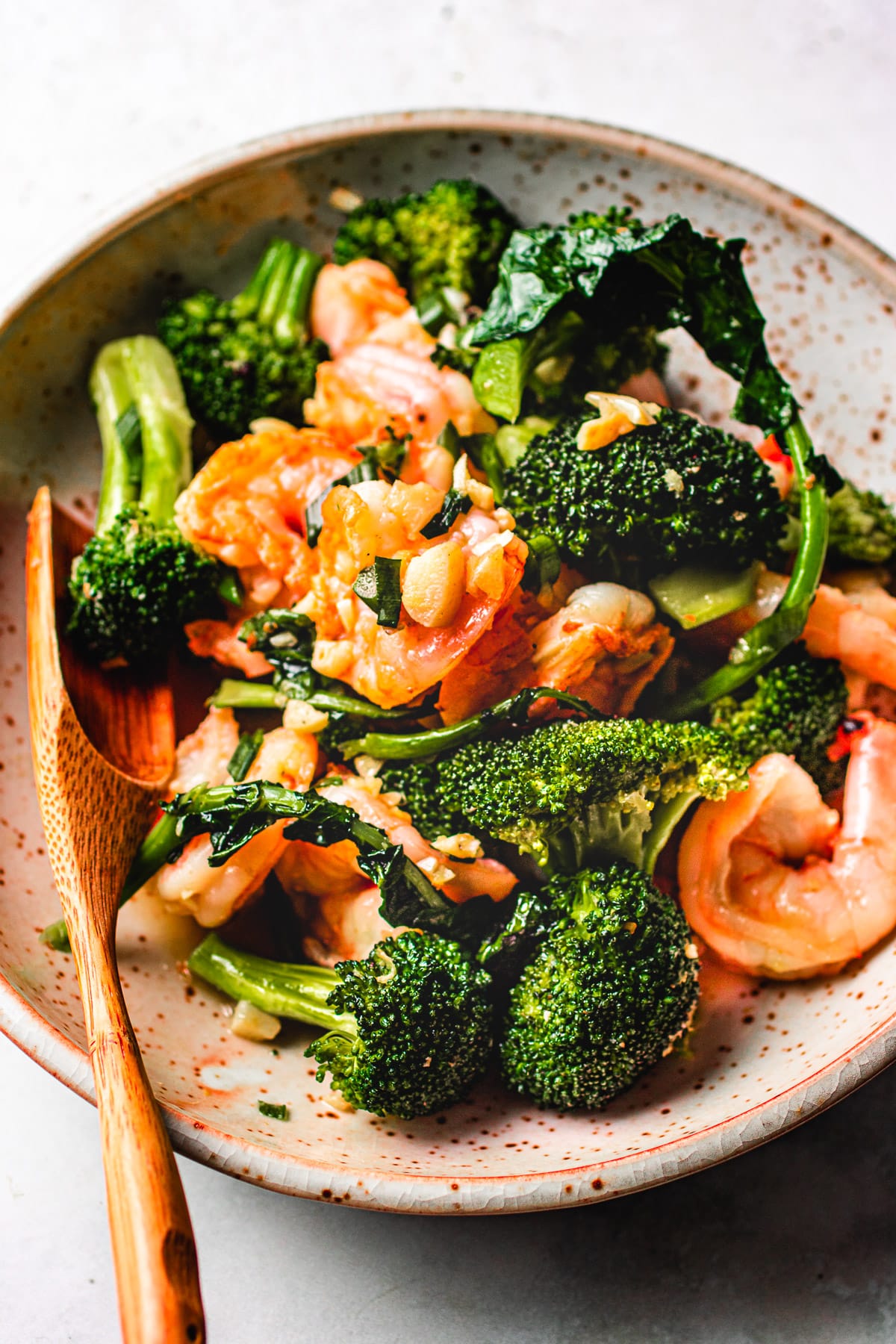Image shows Chinese shrimp and broccoli stir fry dish served on a plate.