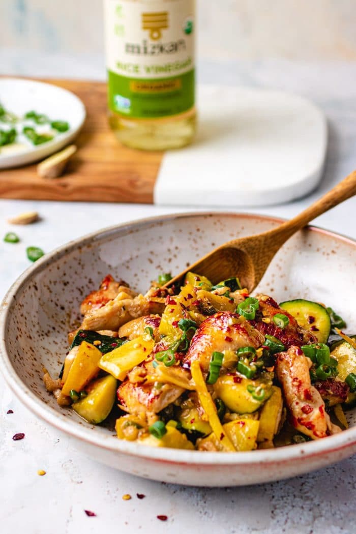 Stir-fried chicken with ginger served on a plate with a spoon
