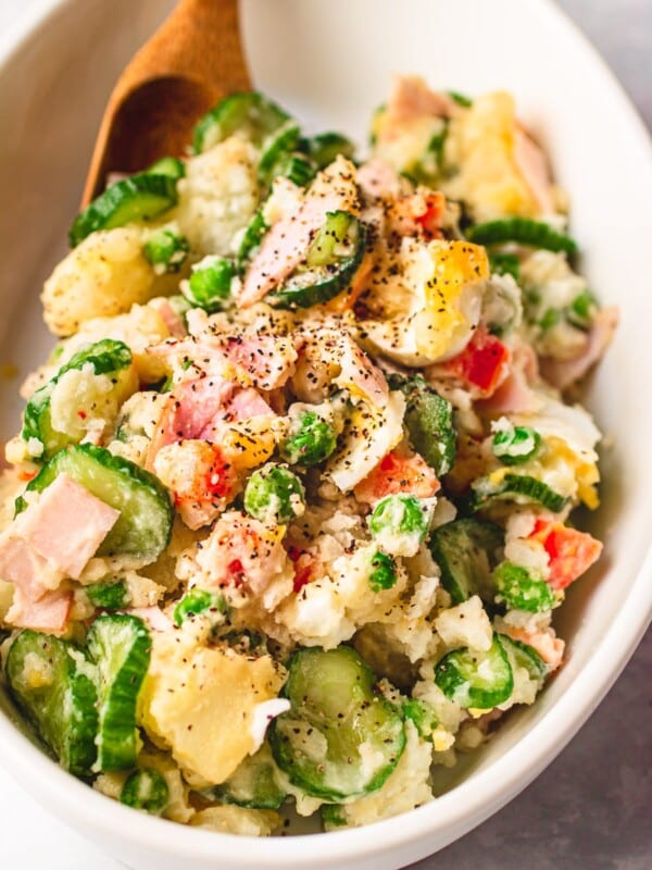 Photo shows Japanese style potato salad served in a white color oval dish.