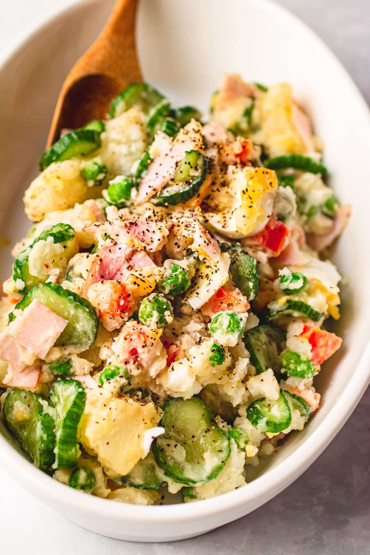 Photo shows Japanese style potato salad served in a white color oval dish.