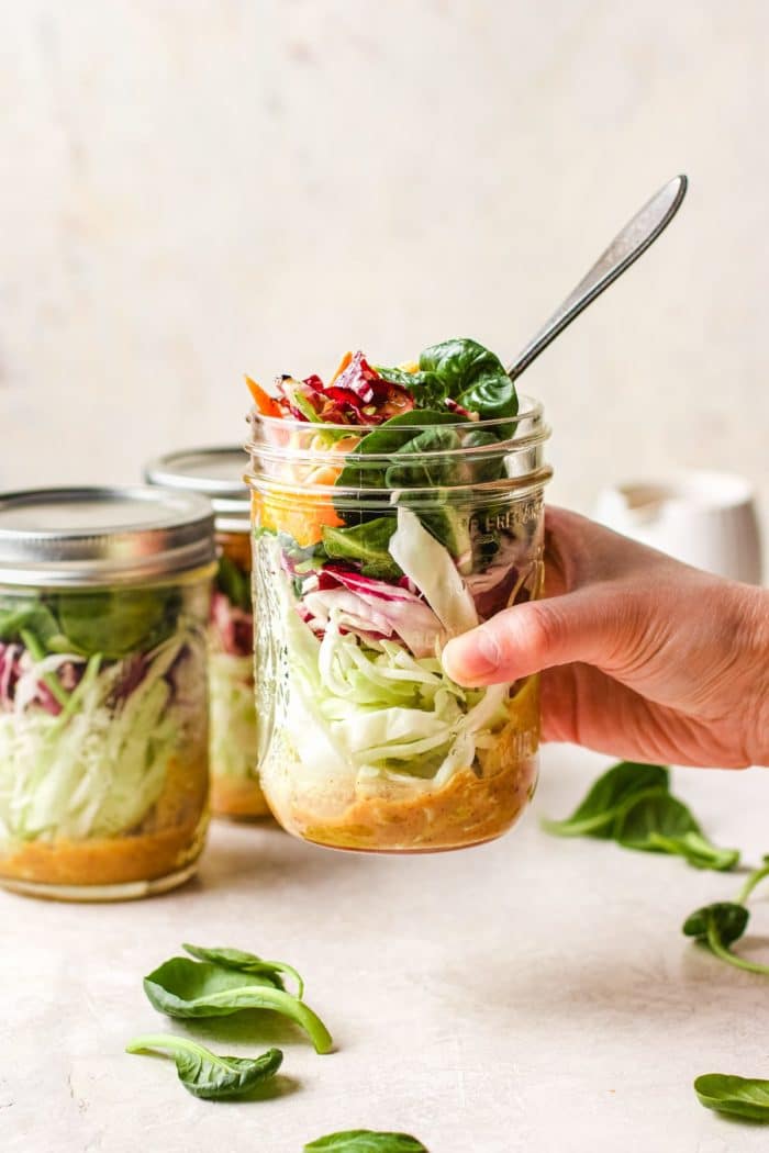 Image shows packing the salad in a big mason jar for portable meal