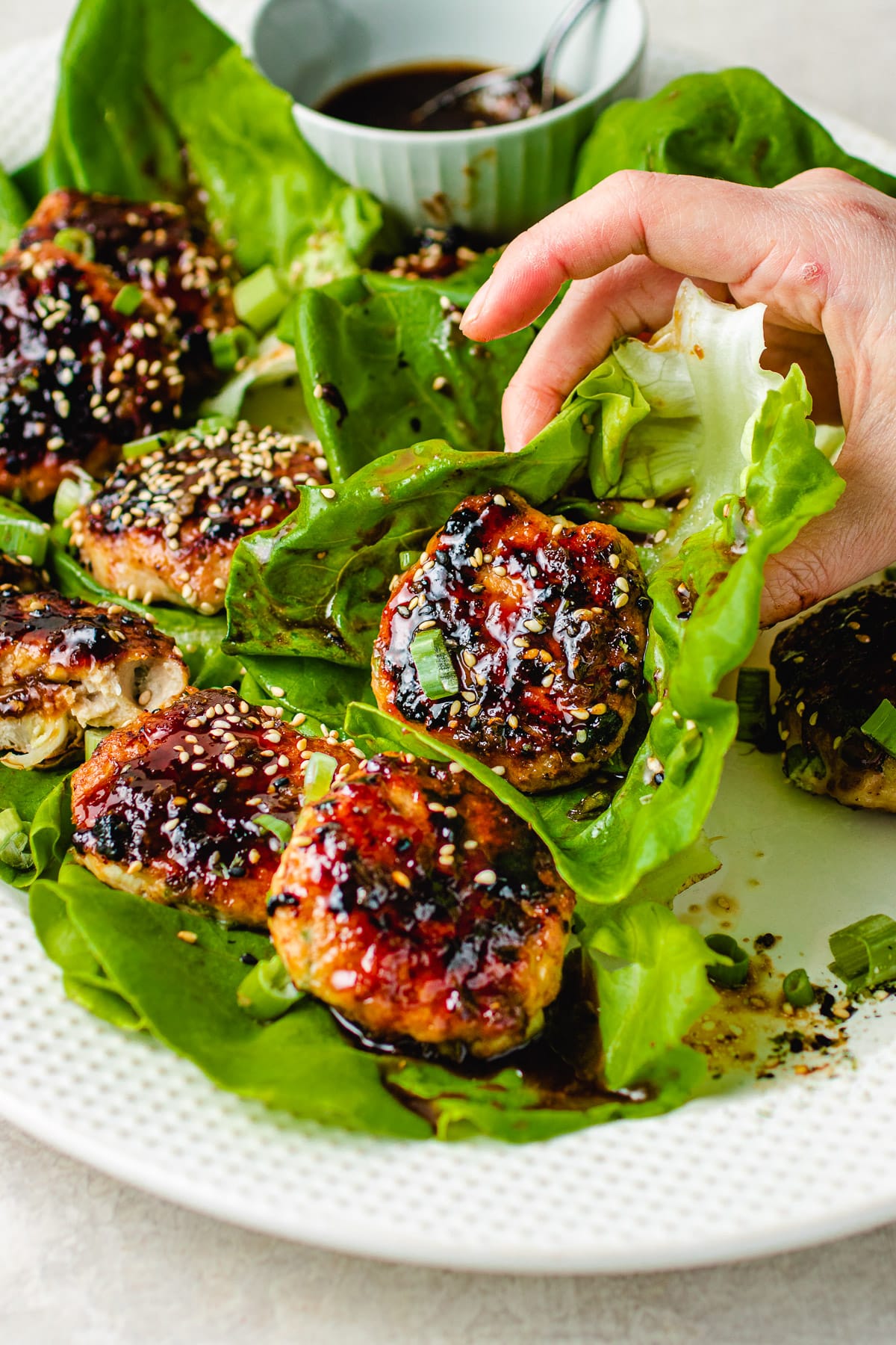 Tsukune meatballs served with lettuce wraps and brushed with yakitori sauce.