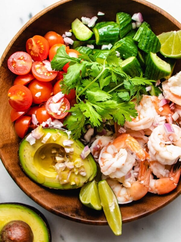 A photo of poached shrimp salad with avocado cucumber tomatoes