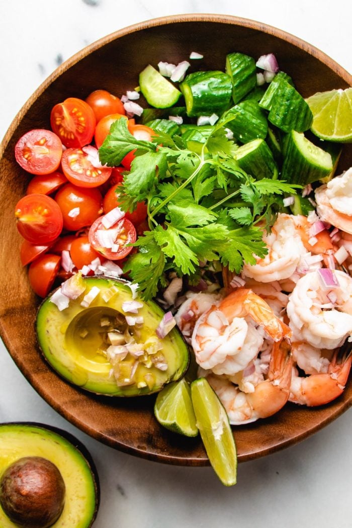 A photo of poached shrimp salad with avocado cucumber tomatoes