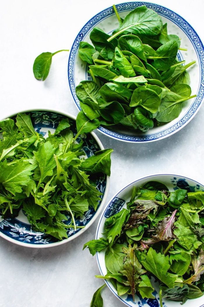 Photo shows individual bowls of tatsoi, mizuna, and spicy asian greens