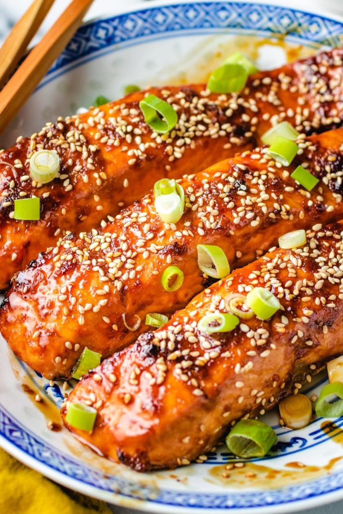 Photo shows garnishing the fish with sesame seeds and scallions