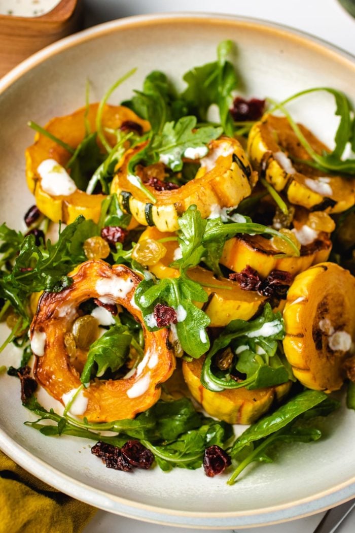 A plate shows baked squash delicata recipe