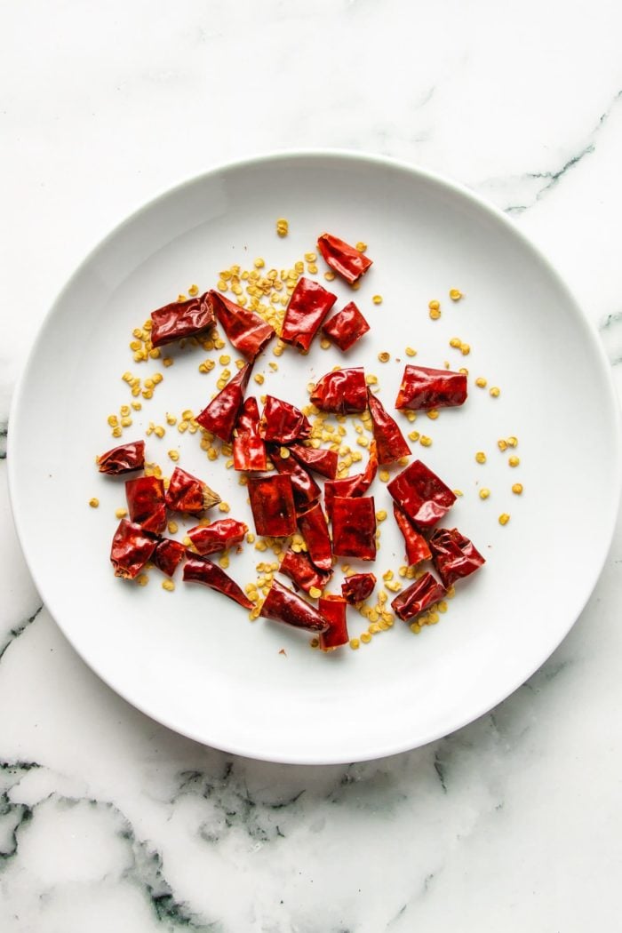 A photo shows Chinese dried red chilis cut open with seeds exposed and discarded