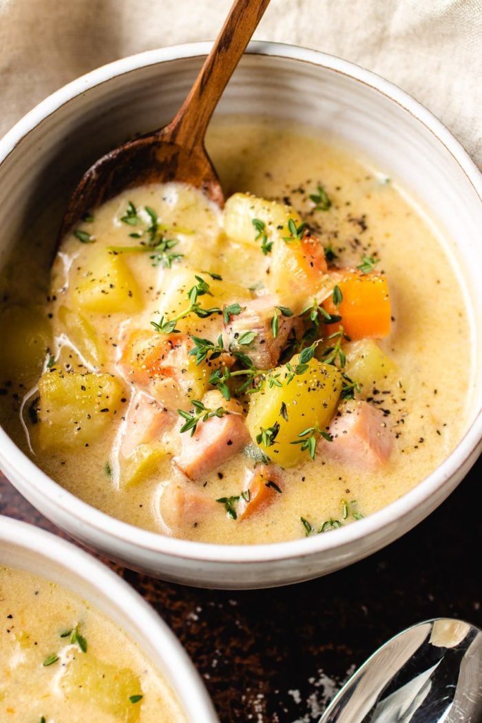 Creamy ham chowder with potatoes in a white bowl