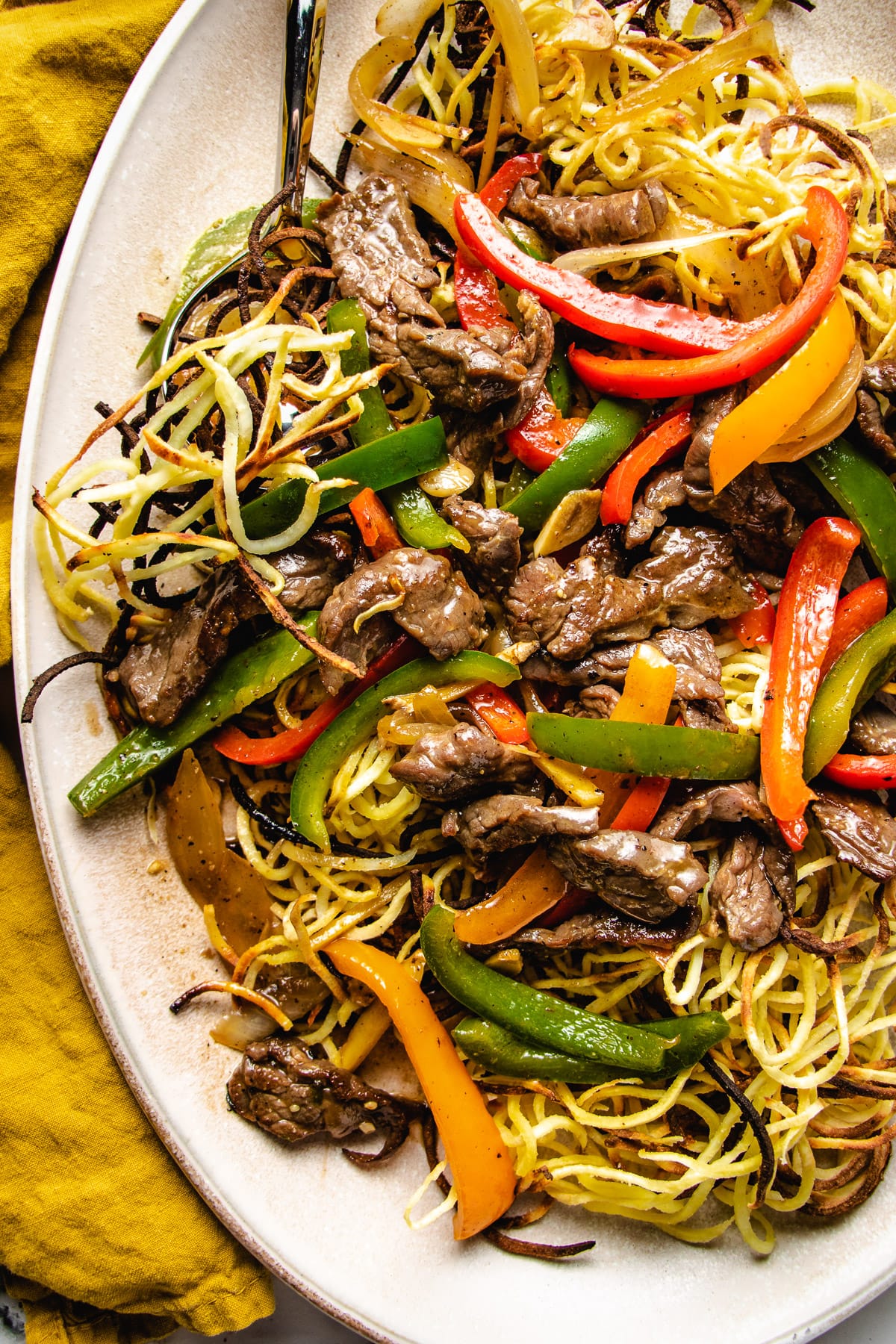 A close shot shows the chow mein and beef in an oval plate