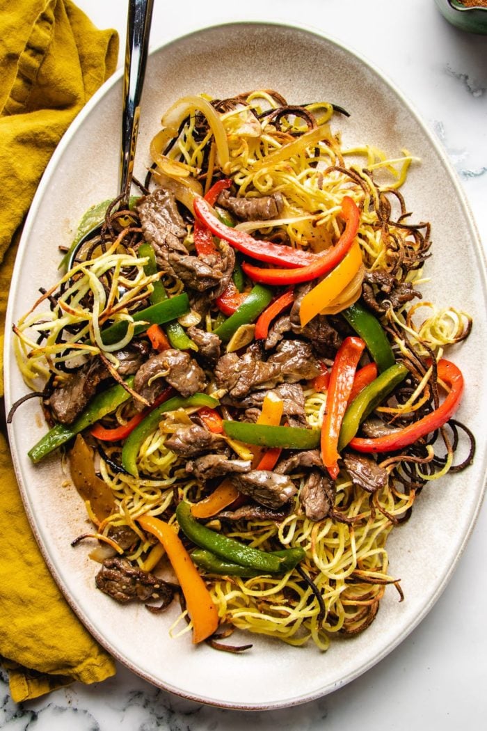 Cantonese beef chow mein feature images served on a large oval plate