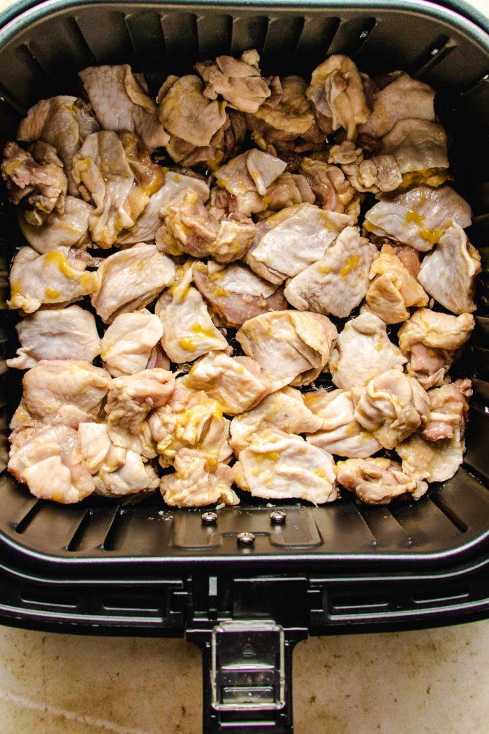 Place the marinated chicken thighs skin side up in the fryer basket