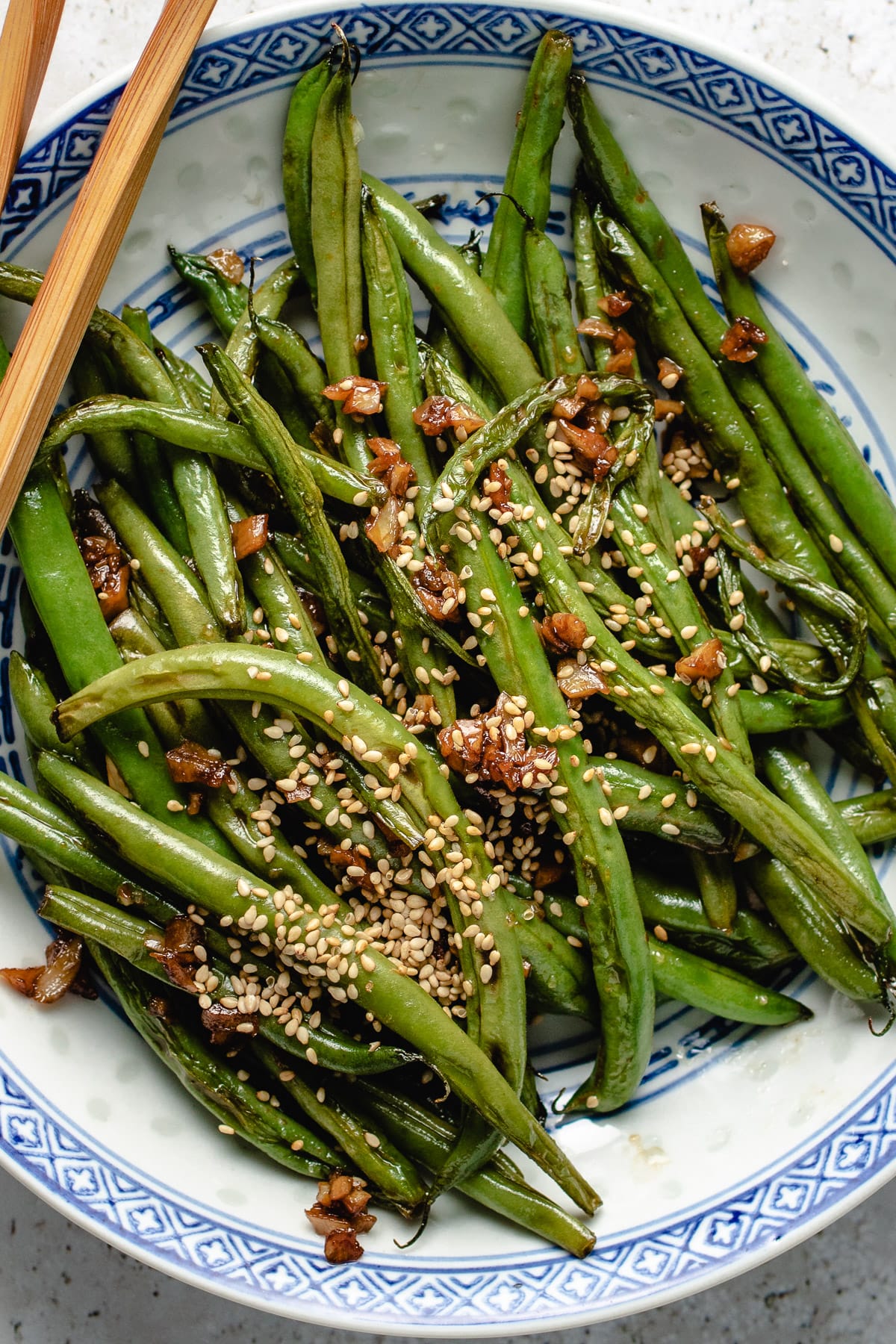 Photo shows crisp Chinese string beans stir fried with garlic and garnish with toasted sesame seeds.