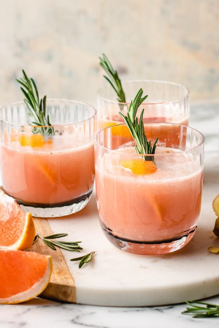 Photo shows 3 chilled sake cocktail drinks with grapefruits, rosemary. 