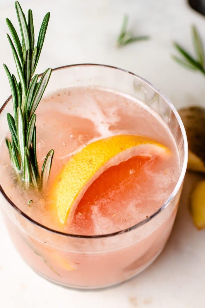 Adding rosemary and grapefruit slice to sake cocktail