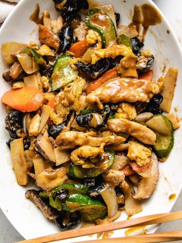 Moo Shu Chicken stir-fry with vegetables and sauce on a big white plate