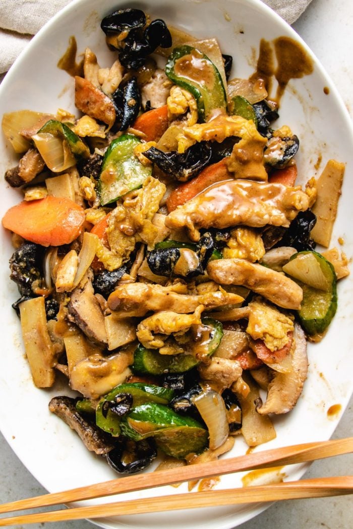 Moo Shu Chicken stir-fry with vegetables and sauce on a big white plate