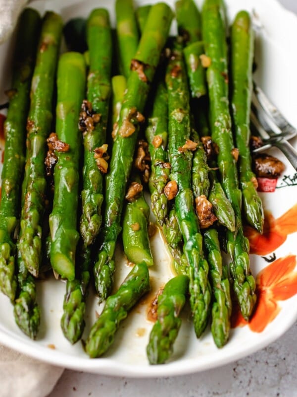 Easy Sauteed Asparagus with miso butter sauce served in a white plate