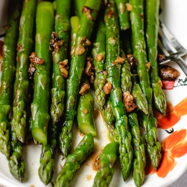Easy Sauteed Asparagus with miso butter sauce served in a white plate