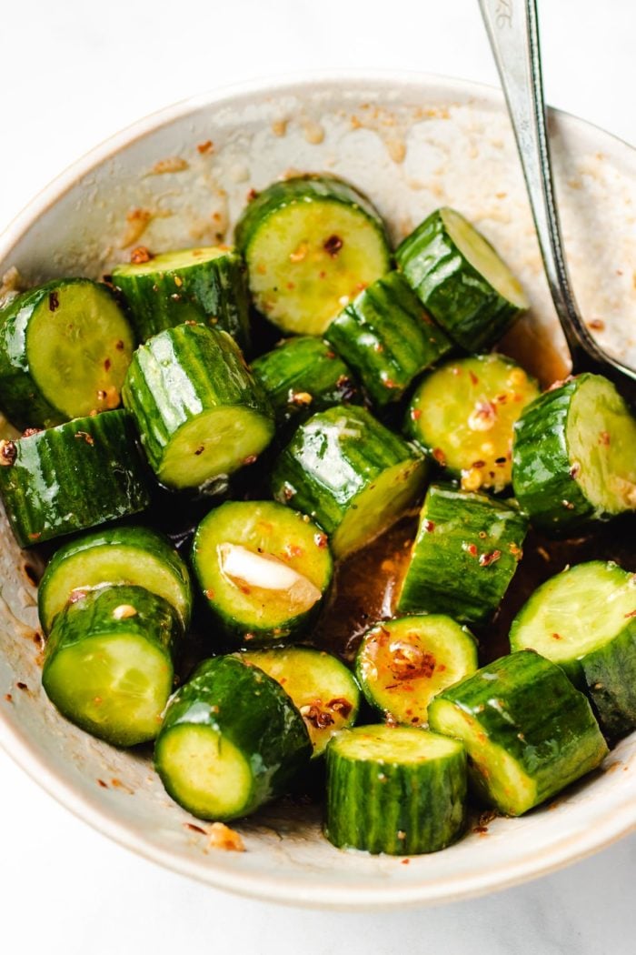 A serving bowl shows the Chinese cucumbers salad tossed in chili honey sauce
