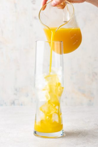 Pour the orange mango juice into a glass filled with ice